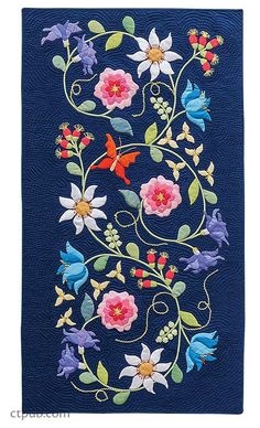 a blue wall hanging with flowers and butterflies on it