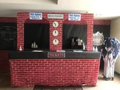 a red brick wall with two ticket booths on it