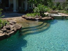 an outdoor swimming pool surrounded by trees and rocks