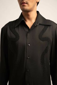 Made in IndiaElevate your ensemble with The Onyx Shirt—a regular-fit black satin masterpiece. Imbued with understated luxury, meticulously crafted black hand beadwork details adorn the shirt, adding a refined touch to your sophisticated style.FabricsShell: Viscose Moss Crepe Satin, IndiaMaintenance• Dry Clean Only• Do Not Bleach• Steam Iron OnlyModel is wearing UK Size Medium, Height 181 cmXS: 36 inches (bust), 33 inches (waist), 38 inches (hips)S: 38 inches (bust), 35 inches (waist), 40 inches Cocktail Shirts Men, Aza Fashion Mens, Designer Black Semi-formal Top, Designer Black Tops For Semi-formal Occasions, Embellished Long Sleeve Shirt For Formal Occasions, Elegant Black Embellished Shirt, Formal Black Embellished Blouse, Luxury Black Party Shirt, Black Embellished Shirt For Party