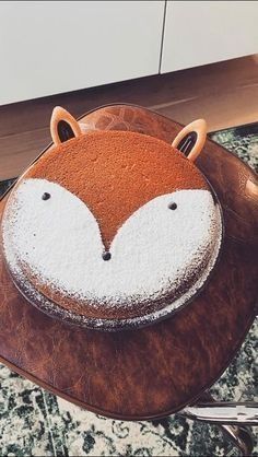 a brown and white backpack with a fox face on the front, sitting on top of a table