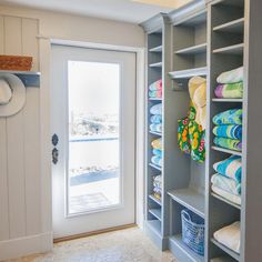 a walk in closet with lots of towels and blankets on the shelves next to it