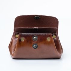 a brown leather purse sitting on top of a white table