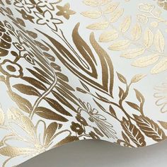 gold and white floral wallpaper with metallic foil on the edges, in an ornate pattern