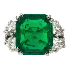 Boucheron Colombian emerald and diamond ring. Centrally set with a cushion shape old mine cut natural Colombian emerald with indications of minor clarity enhancement in an open back claw setting with an approximate weight of 6.20 carats, further adorned with four drop shape old mine diamonds in open back claw settings with a combined approximate weight of 2.10 carats, to an impressive flanked solitaire design featuring double corner claws, a linear pierced gallery and open backholing, the raised David Morris, 1920 Art, 1920 Art Deco, Emerald And Diamond Ring, Wedding Ring For Her, Gem Diamonds, Emerald Diamond Ring, Detailed Jewelry, Mid Century Jewelry