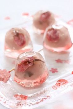 some pink desserts sitting on top of a clear plate