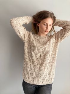 a woman is wearing a sweater and holding her head