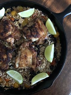 chicken and rice in a skillet with lime wedges