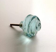 a close up of a glass door knob on a white surface with light coming through it