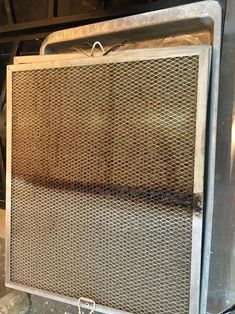 an old fashioned oven sitting on top of a metal shelf next to a trash can