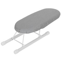 a gray ironing board sitting on top of a white stand