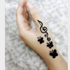 a woman's hand with black flowers and musical notes on it