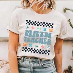 a woman wearing a white t - shirt with the words math teacher printed on it