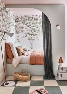 a bedroom with pink and white flowers on the wall, checkerboard flooring