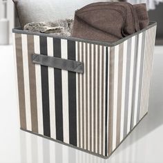 a striped storage box with clothes in it