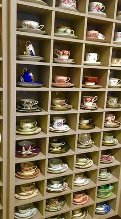 the shelves are filled with many different kinds of cups and saucers