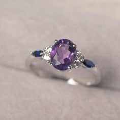 * The delicate ring displays Amethyst as main stone. The cluster side stones make the ring similar to the blooming flower . For who wearing this special & delicate ring, will shine like a goddess. ◆ Production Description: Main stone Type: Amethyst Main Stone Shape: Oval Cut Main Stone Size: 6*8mm (1.14ct) Side stone: CZ & lab sapphire Metal: 925 Sterling silver - Other options available in the drop down menu ◆ Customization: √Free for Add Engraving √Other Metal Type Available √Other Gem Classic Sapphire Rings In Purple, Delicate Sapphire Gemstone Ring For Anniversary, Delicate Amethyst Gemstone Ring For Anniversary, Delicate Sapphire Ring For Anniversary, Oval Amethyst Ring With Accent Stones For Anniversary, Lavender Diamond Oval Ring, Oval Flower Ring With Center Stone For Promise, Lavender Oval Diamond Ring, Purple Sapphire Gemstone Rings