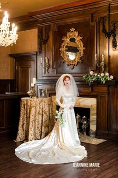 a woman in a wedding dress standing next to a fireplace