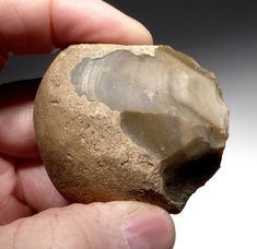 a person holding a rock in their left hand with a piece of stone inside it