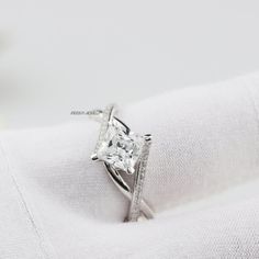 a white gold ring with a princess cut diamond