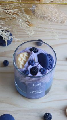 a glass container filled with blueberries and waffles on top of a wooden table