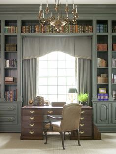 an office with bookshelves, desk and chair in front of a large window