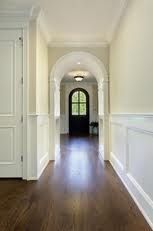 an empty hallway with wood flooring and green markers on the wall to indicate that there is no one in the house