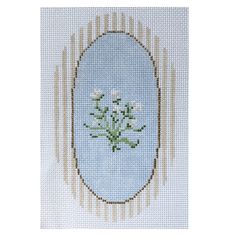 a cross stitch picture with flowers in the center and an oval frame on it's side