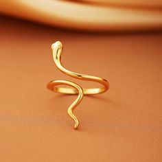 Embrace the timeless elegance and symbolism of our Snake Ring collection. These stunning rings, are designed to add a touch of sophistication and mystique to any outfit. Features: Material: High-quality silver with a luxurious gold plating, ensuring durability and a beautiful shine. Design: The ring features a smooth, vintage-inspired snake design that wraps gracefully around your finger. Its minimalist style makes it perfect for stacking or wearing solo as a statement piece. Adjustable Fit: The Symbolic Open Snake Promise Ring, Minimalist Yellow Gold Snake Ring, Minimalist Yellow Gold Open Snake Ring, Minimalist Adjustable Snake-shaped Ring, Adjustable Minimalist Snake-shaped Rings, Minimalist Snake Ring For Anniversary, Minimalist Adjustable Snake Shape Rings, Minimalist Snake Ring As A Gift, Stunning Rings