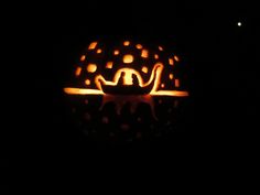 a pumpkin carved to look like a cat sitting on top of a table in the dark