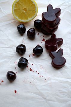 an orange slice and some black olives on a white tablecloth with blood spilled around it