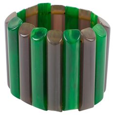 This is a remarkable Bakelite bracelet bangle that I think you'll love. The stretch design and oversized shape make it a rare find, and the carved sticks in alternating emerald green marble and dark mouse gray colors add to its unique appeal. It was crafted in France during the 1940s and has its original stretch link, which is still safe to wear. Although there is no visible maker's mark, the quality of this piece speaks for itself. The bracelet is in good condition, with a tiny chip on one of t Green Stretch Bangle Bracelet, Artisan Green Cuff Bangle Bracelet, Green Bangle Jewelry Collectible, Artisan Green Bangle Bracelet, Green Bangle Bracelet Wearable Art, Bakelite Bracelets, Bakelite Bangles, Red Arrow, Grey Marble