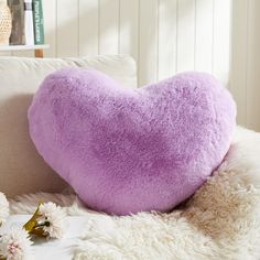 a heart shaped pillow sitting on top of a couch