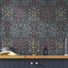 an ornate wallpaper design in blue and red with gold accents on the kitchen counter