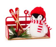 a snowman with a red hat and scarf next to a wooden sleigh