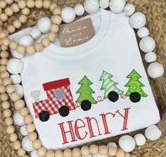 a white shirt that says merry with trees on it and a train in the middle