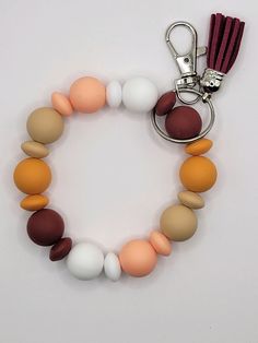 a key chain with various colored beads and a tassel hanging from it's end