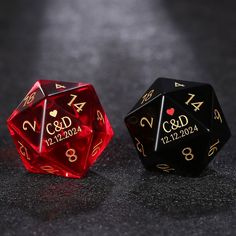 two black and red dices with gold lettering on them sitting next to each other