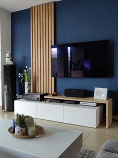 a flat screen tv mounted on the wall above a white entertainment center in a living room