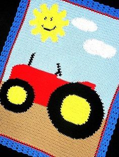 a crocheted baby blanket with a red tractor on it's side and a smiling sun in the sky