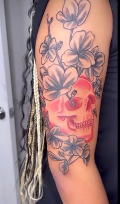 a woman with a skull and flowers tattoo on her arm