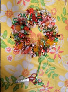 a pair of scissors are laying on a flowered tablecloth with candy and candies