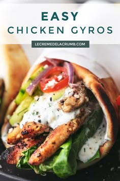 chicken gyros with lettuce, tomatoes and onions on a black plate