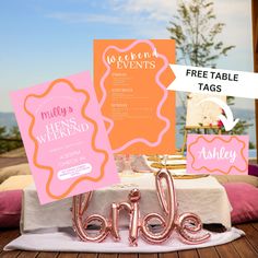 a table topped with pink and orange items next to a sign that says welcome events