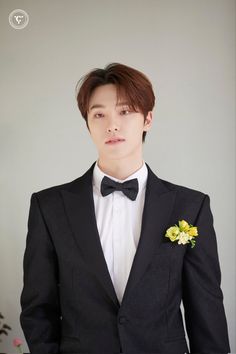 a young man in a tuxedo with a flower on his lapel