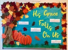 a bulletin board with fall leaves and pumpkins in front of the words, his grace falls on us