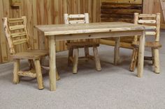 a wooden table and two chairs in front of a wall with logs on the walls