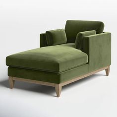 a green chair and footstool sitting next to each other on a white surface