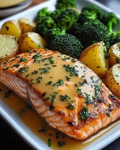 a plate with salmon, potatoes and broccoli on it