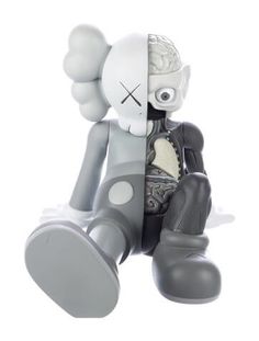 a gray and white figurine sitting on top of a pair of black shoes